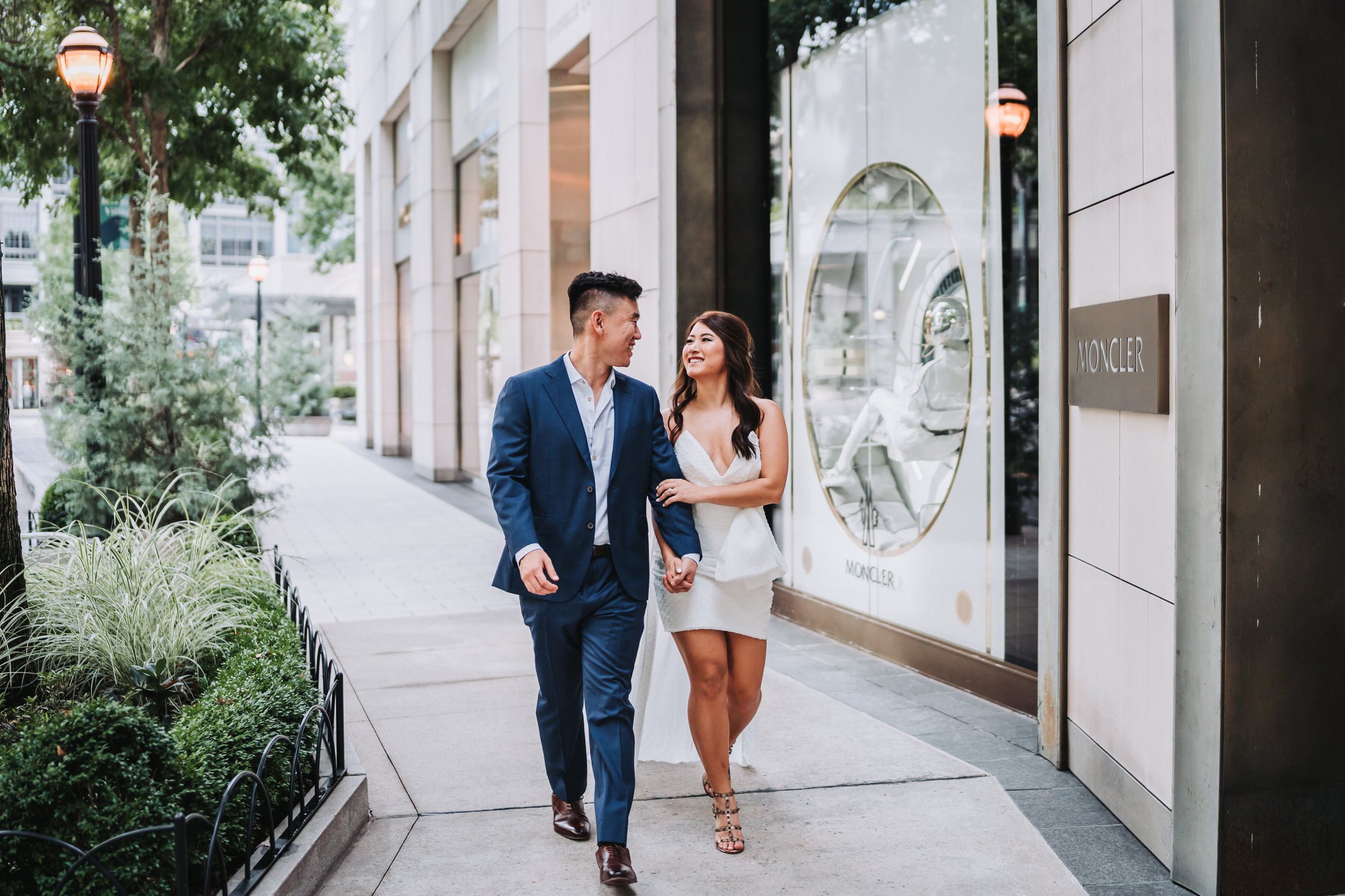 Asian male and female walk towards photographer in Buckhead Village, Atlanta, GA.