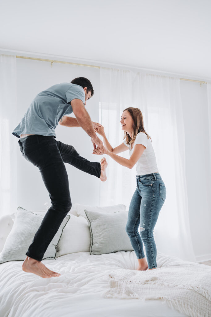 couple jumping on the bed at kiah studios