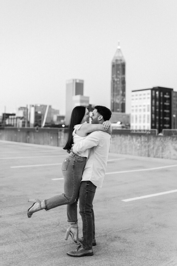guy picks up girl with atlanta city skyline in the background