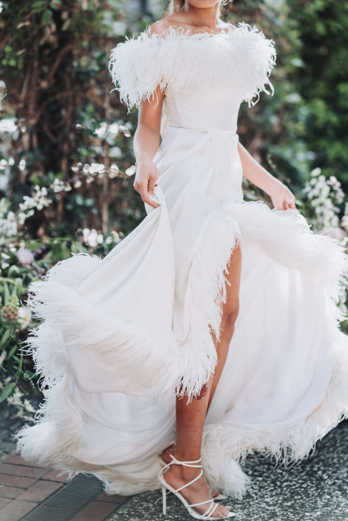 Bride wearing a white dress made out of feathers. Wedding at the Marriott Savannah Riverfront.