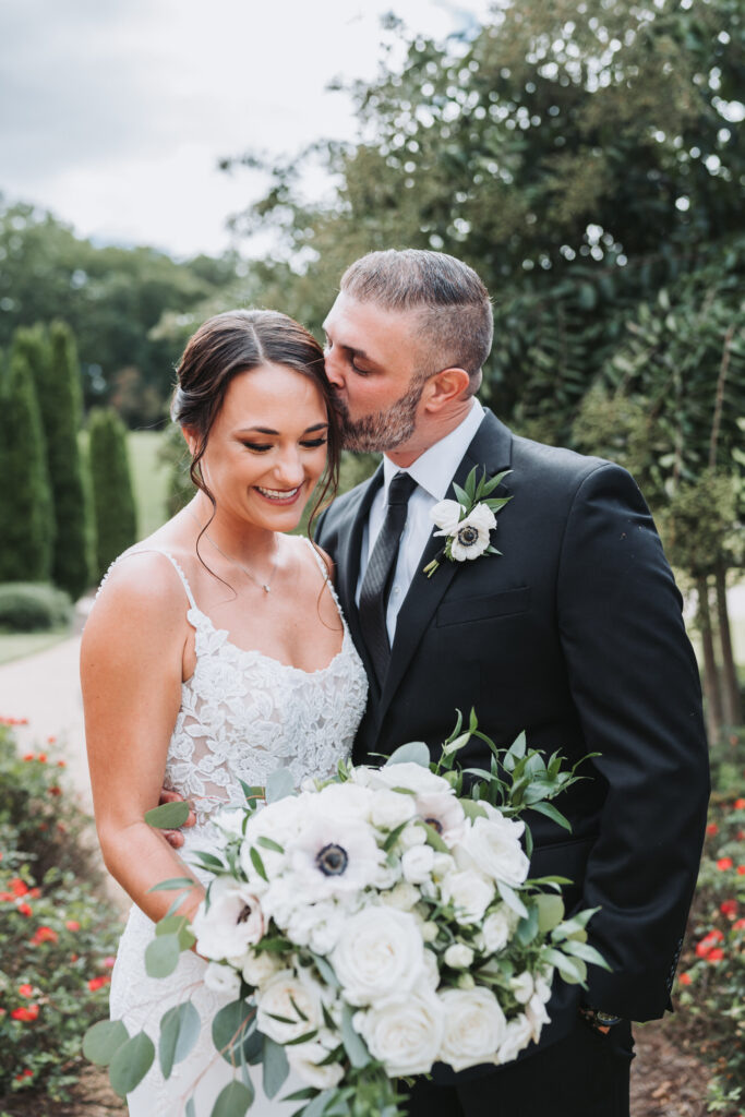 Groom kisses Bride's face.