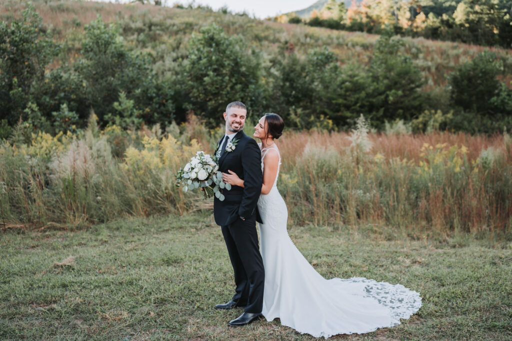 Bride looks at groom with Yonah Mountain in the background.