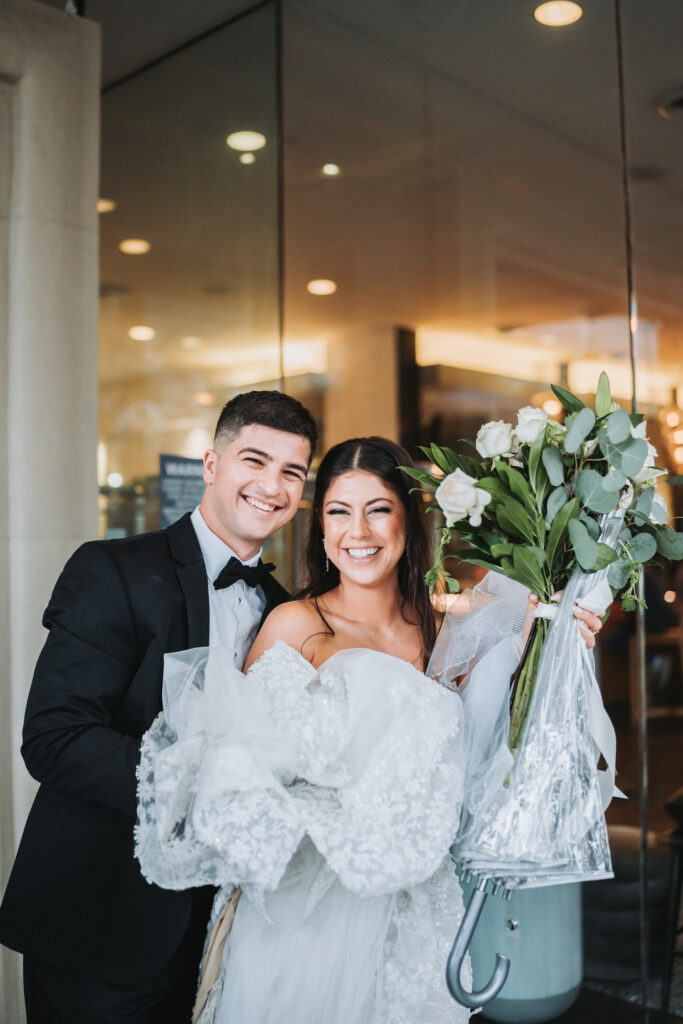 Bride and Groom stand outside of Andaz Hotel while waiting for their car.