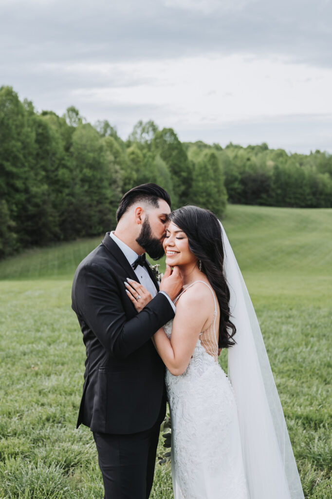 Groom kisses bride's cheek at Meadows at Mossy Creek wedding