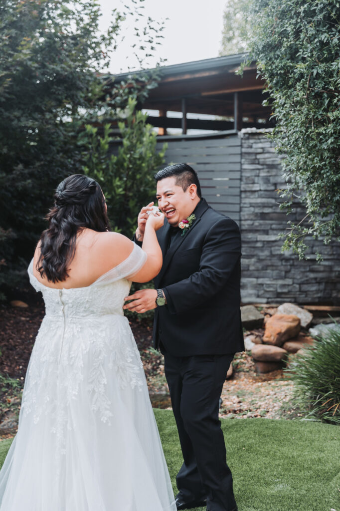 Bride hands groom a tissue while he cries during their first look