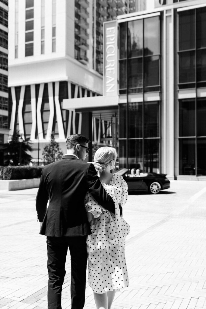 Bride and groom walk towards car in front of Epicurean Hotel atlanta