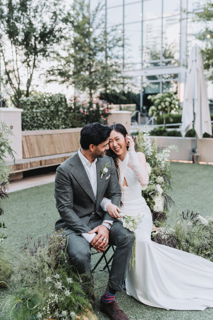 bride brushes hair back and laughs at groom