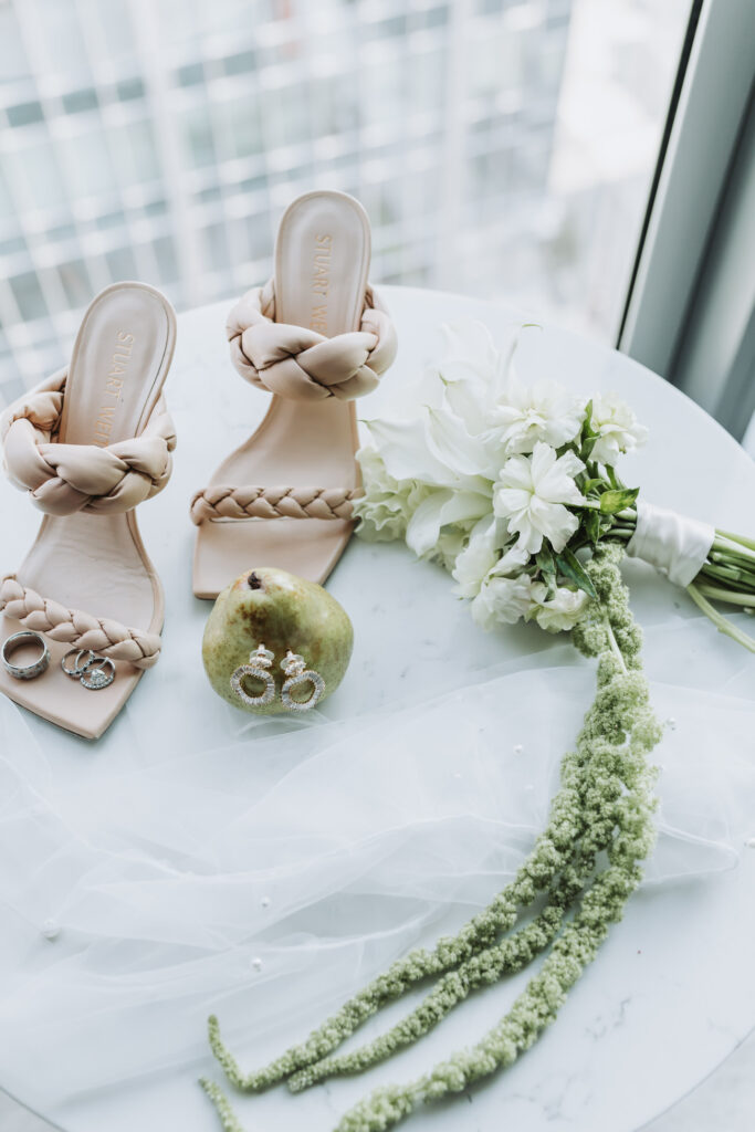 Bride wedding details with green floral bouquet and pears