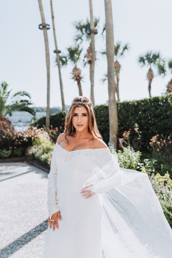 Bride wears off the shoulder wedding dress with detachable cape from Oscar de la Renta.
