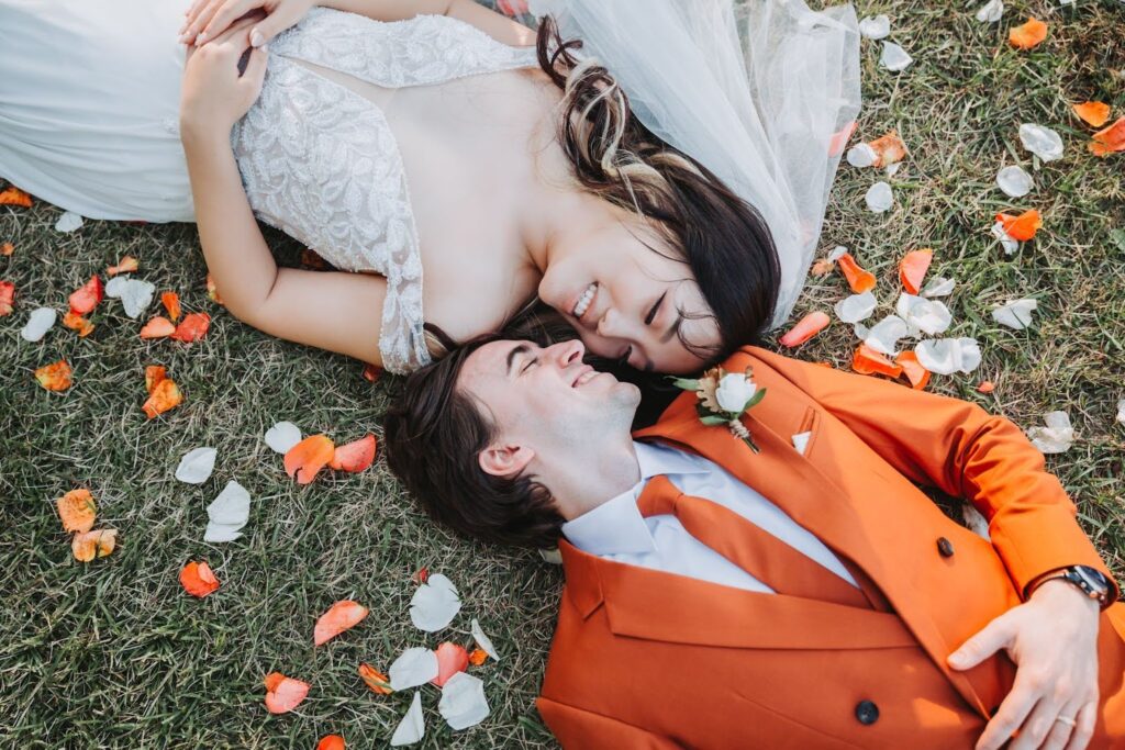 Bride and groom laying on the grass