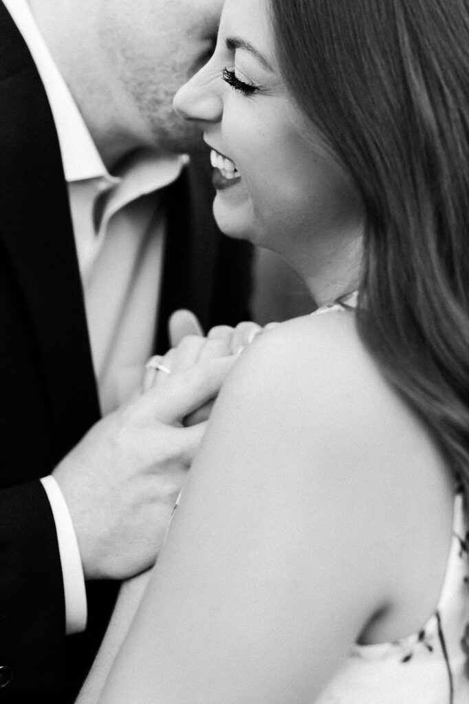 a black and white photo of an engaged couple embracing