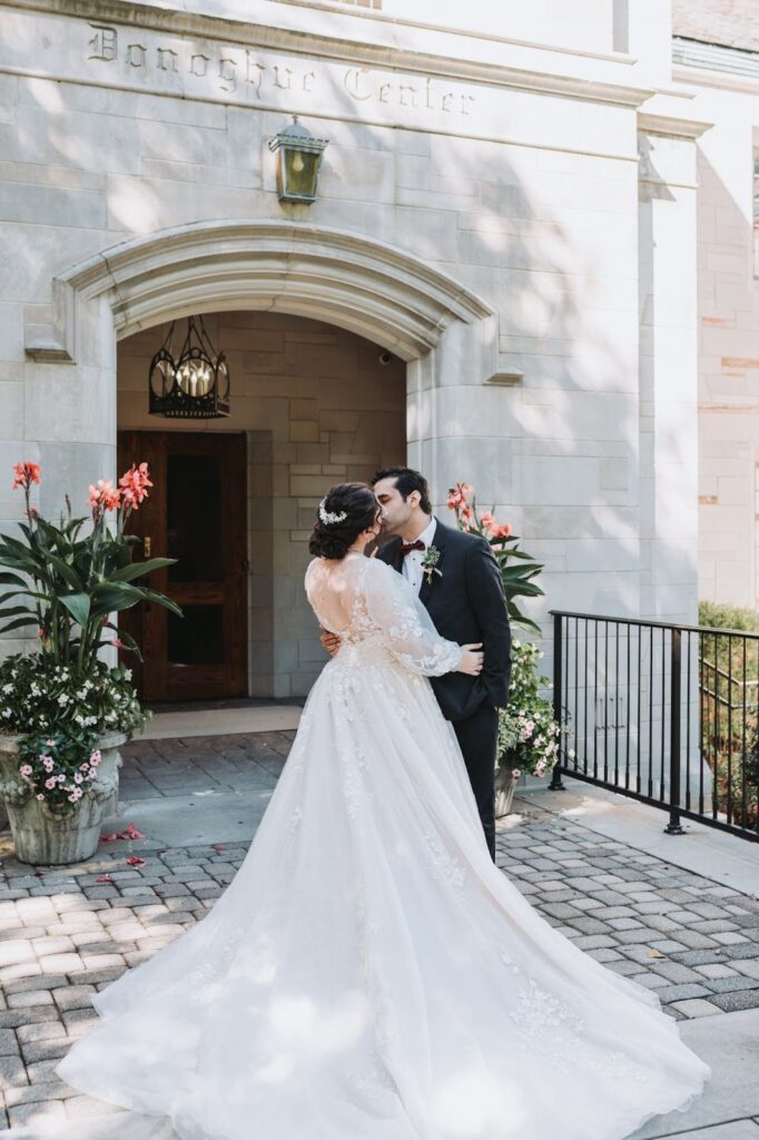 newly married couple being photographed kissing in front of a building