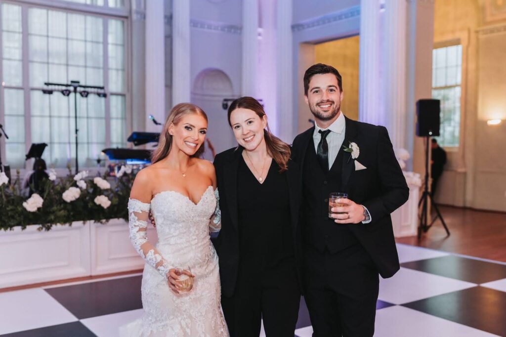 Bride and groom on dance floor with guest