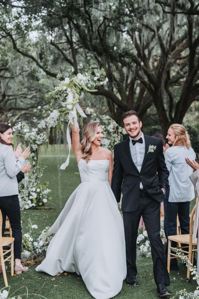 bride and groom walking down isle outside