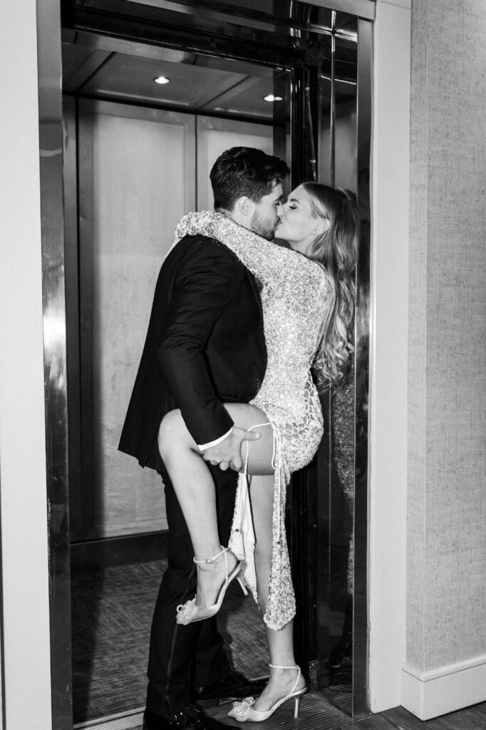 Bride and groom kiss in front of elevator