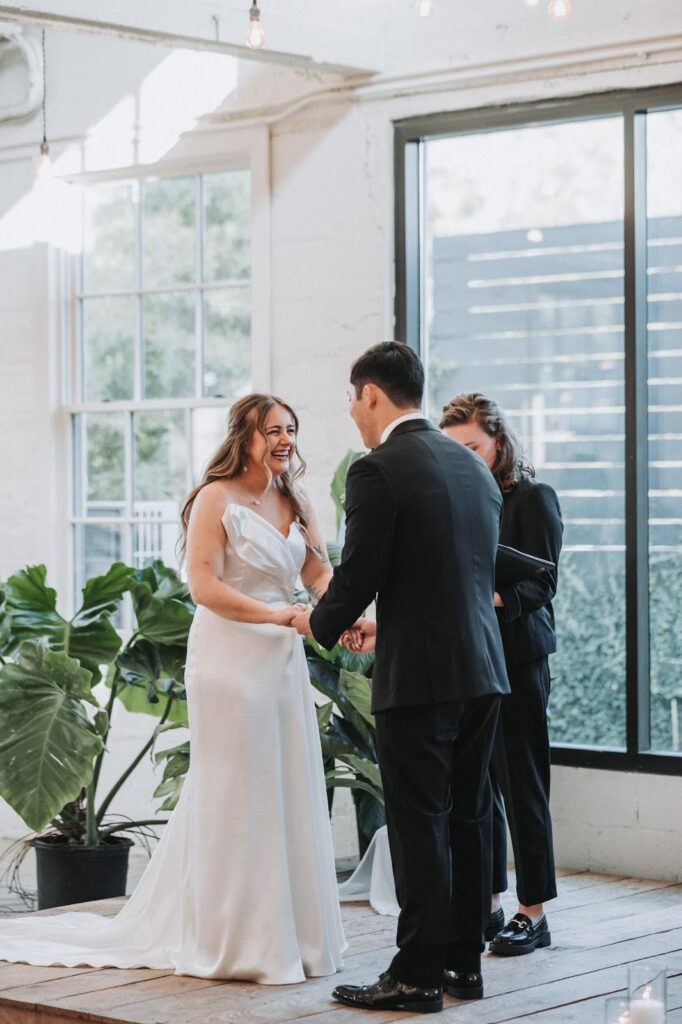 Bride and groom laugh during their wedding ceremony at upstairs atlanta