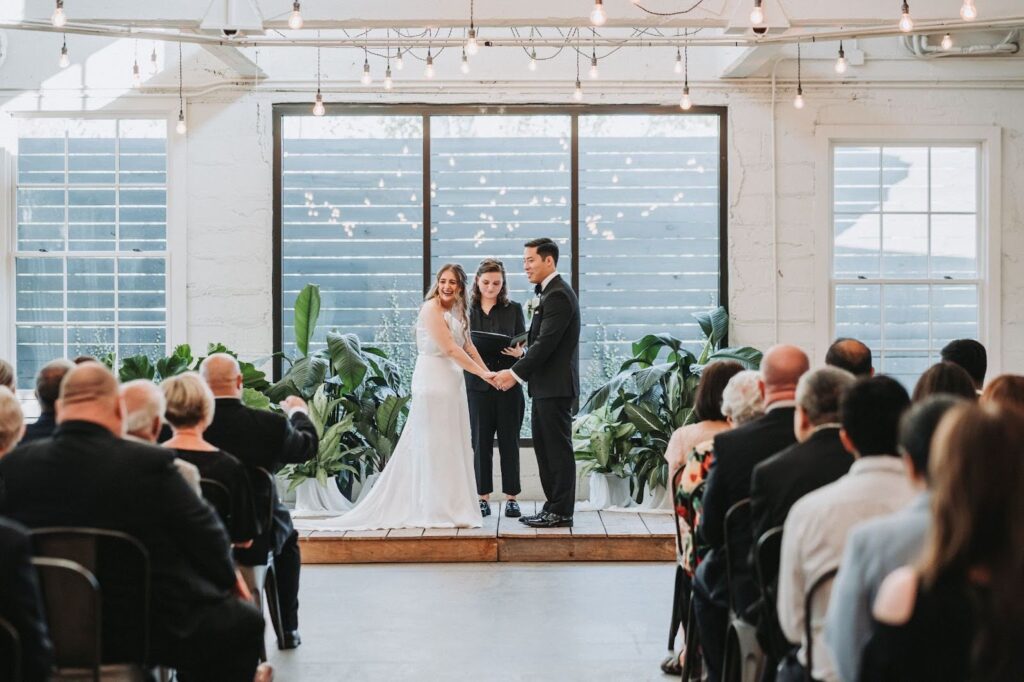 Bride and Groom hold hands during wedding ceremony at upstairs atlanta