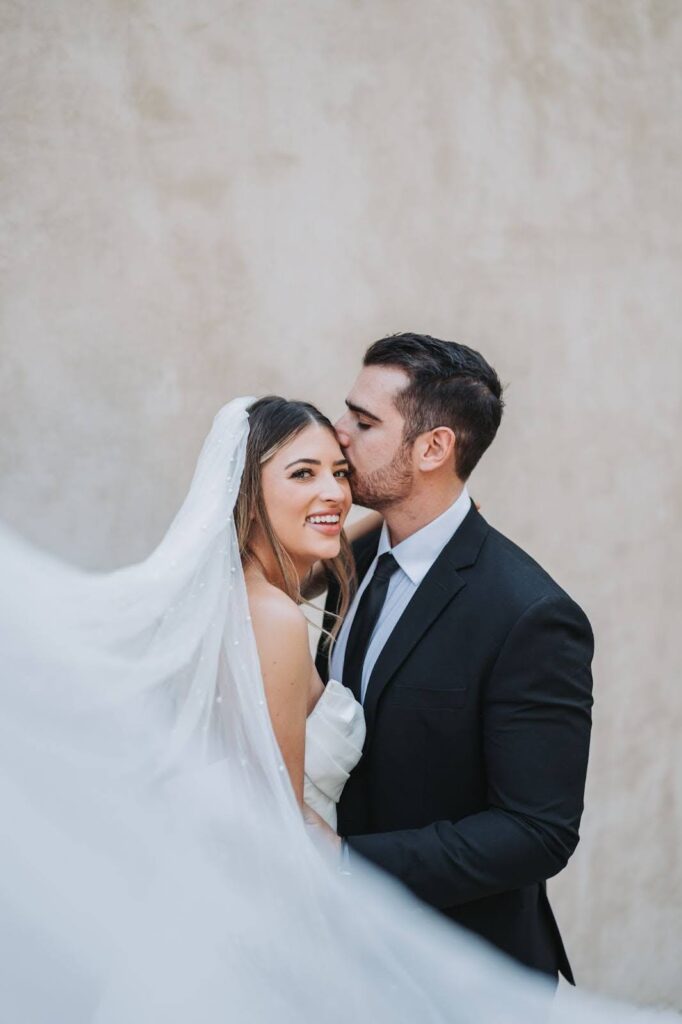 groom kisses bride's cheek