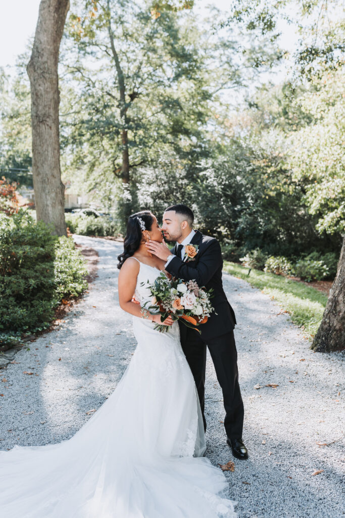Groom kisses bride at their perfect wedding venue, Primrose cottage.