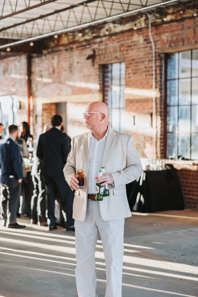 man holds beers in his hand at cocktial hour