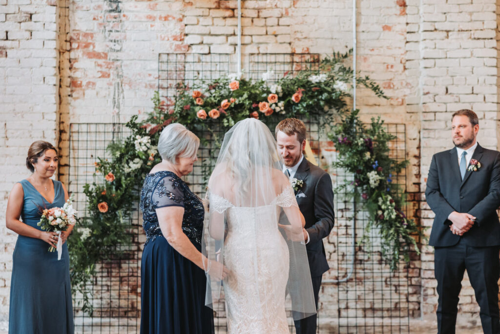 mother of the bride hands off bride to groom