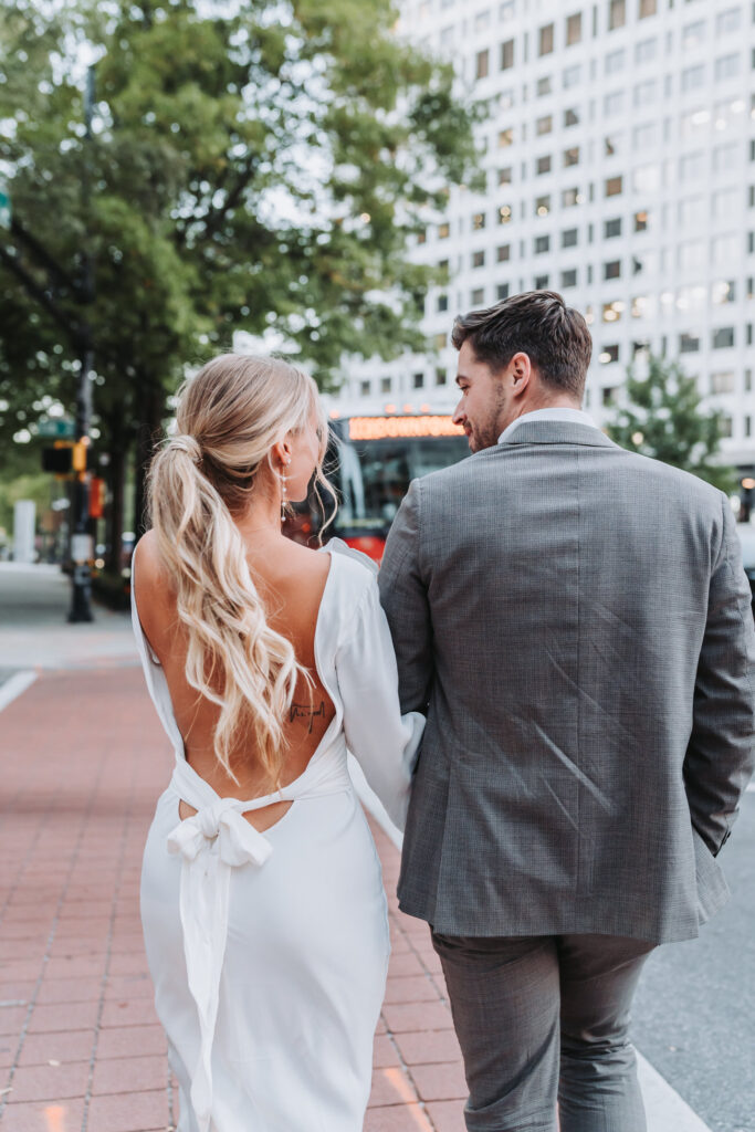 girl and guy walk around city holding hands