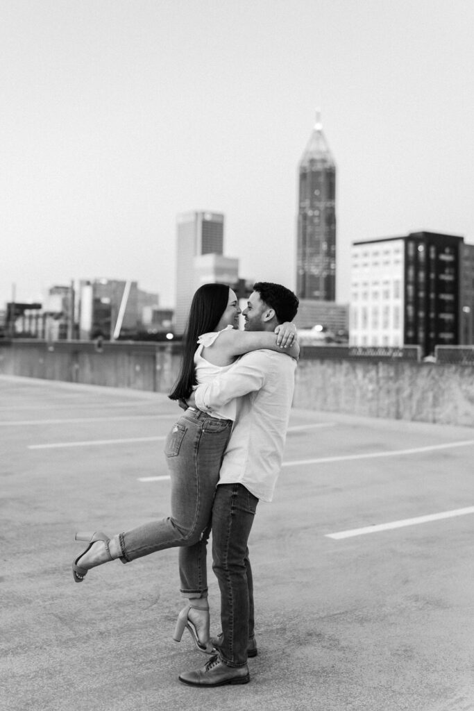 Guy picks up girl with Atlanta cityscape in the background