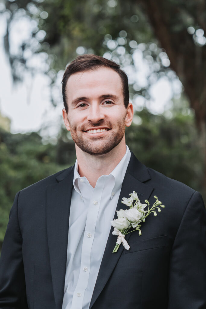 Groom smiling at camera in black suit