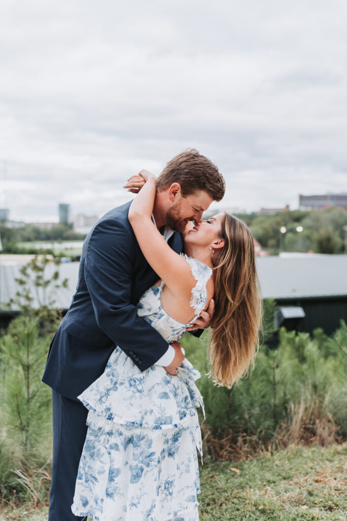 girl kisses guy with cityscape in the background