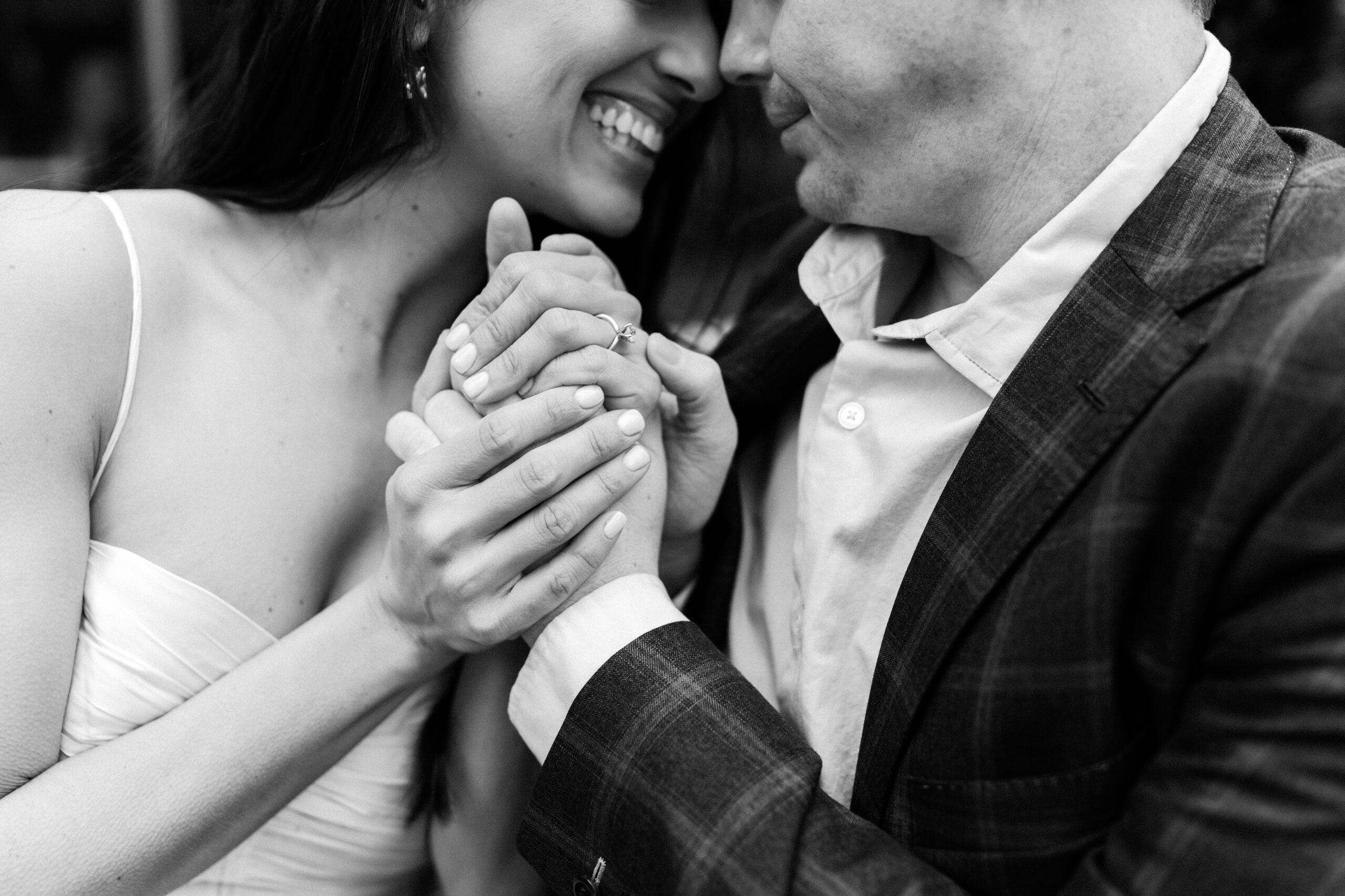 Guy and girl hold hands close to chest.