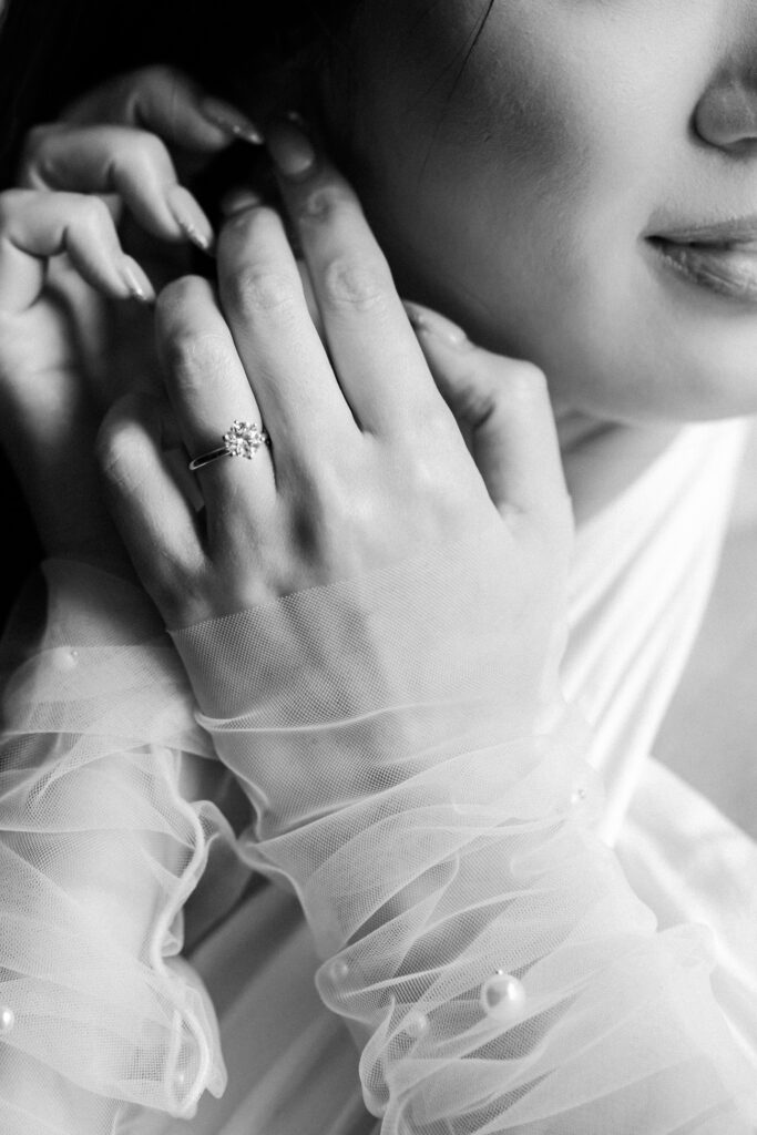 bride gets ready and puts on earrings. There is an upclose photo of her ring
