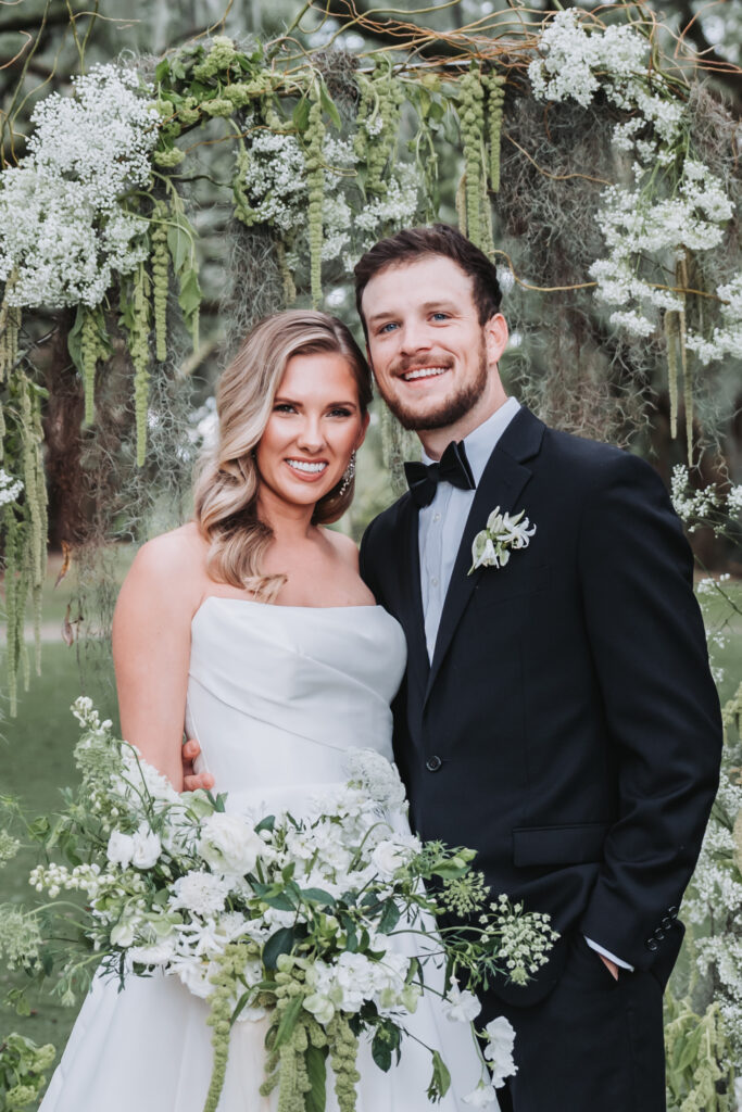 bride and groom smile at camera during portrait