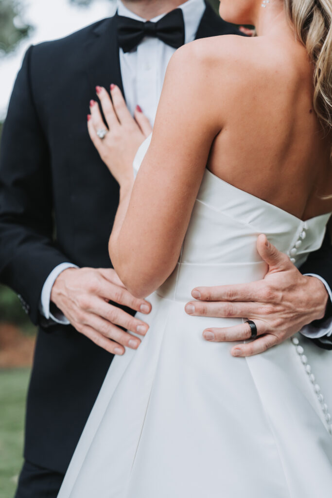 Groom holds bride's waist