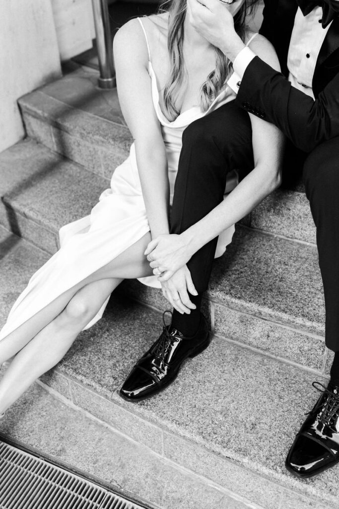 black and white closeup of girl leaning on guy's leg.