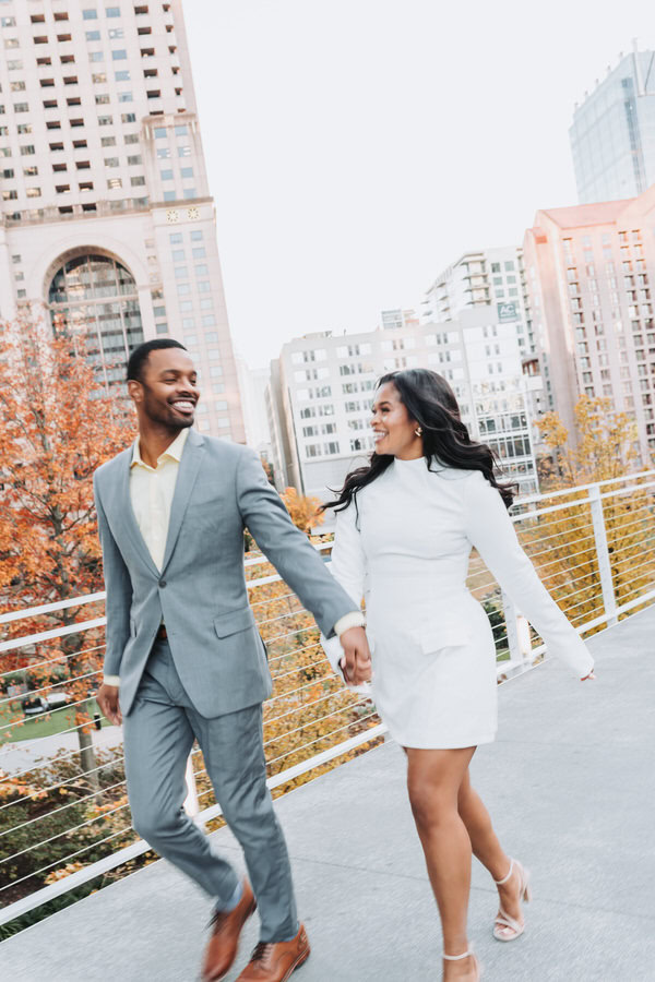 girl and guy run with Atlanta city in the background