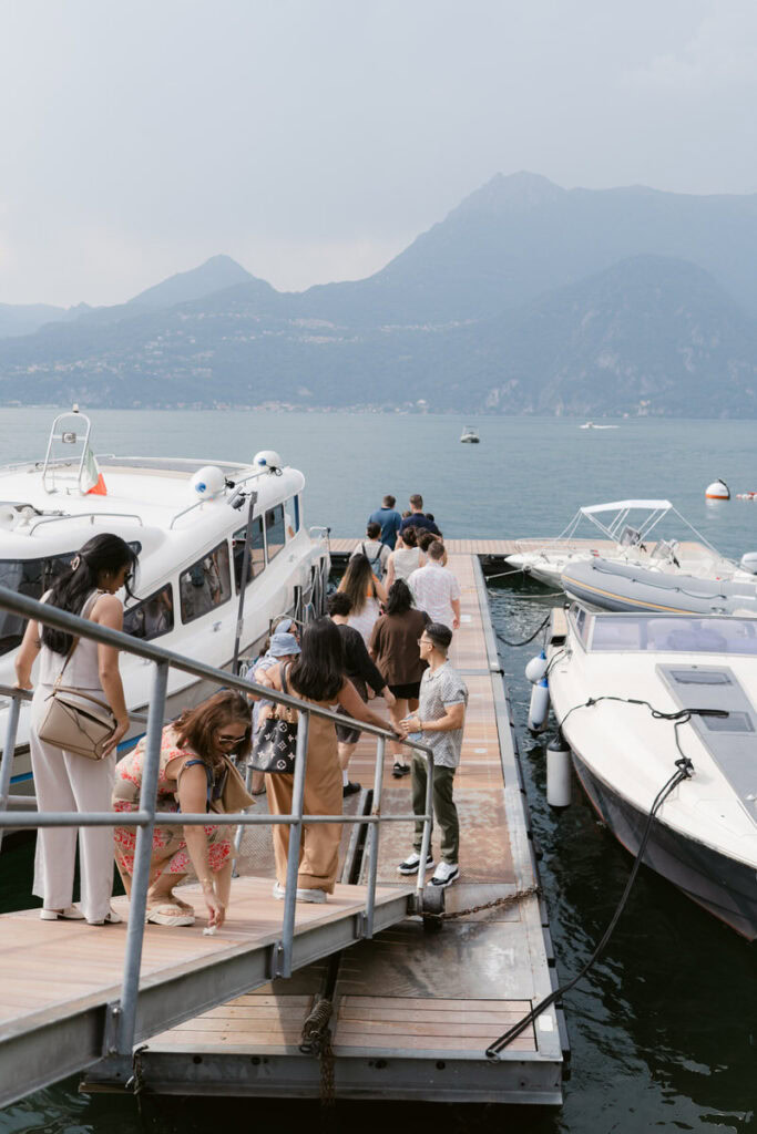 group of people walking on boat ramp to take boat transportation on lake como