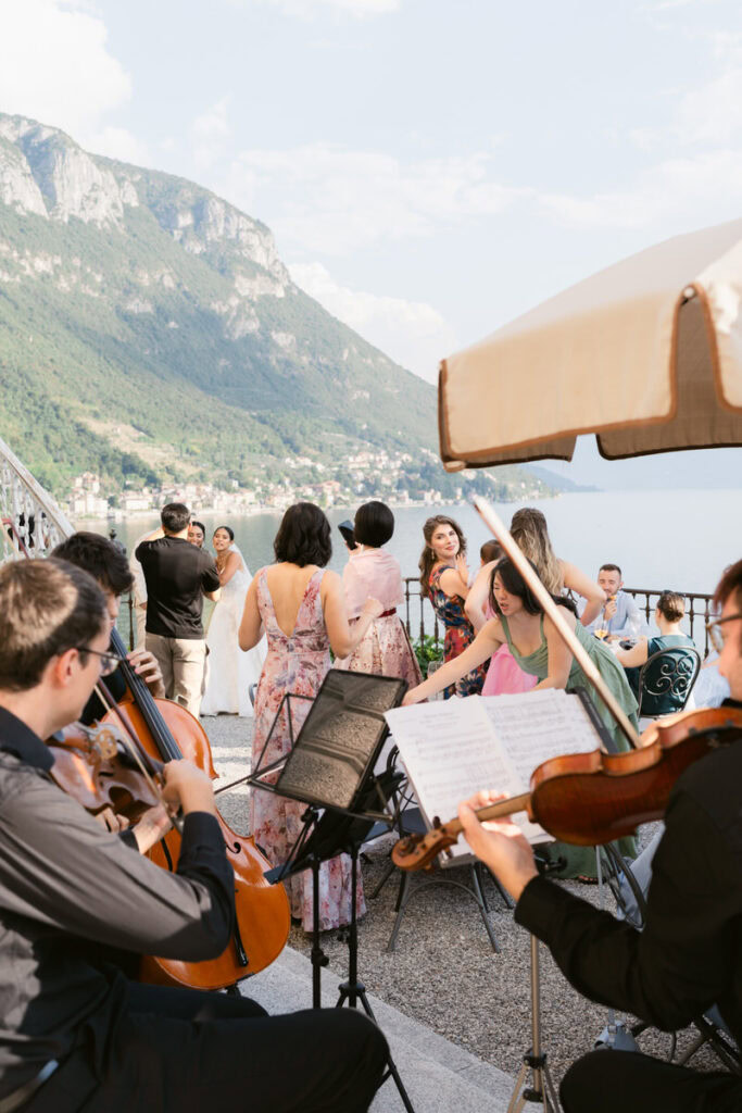 guests mingle at cocktail hour while string musicians play music.