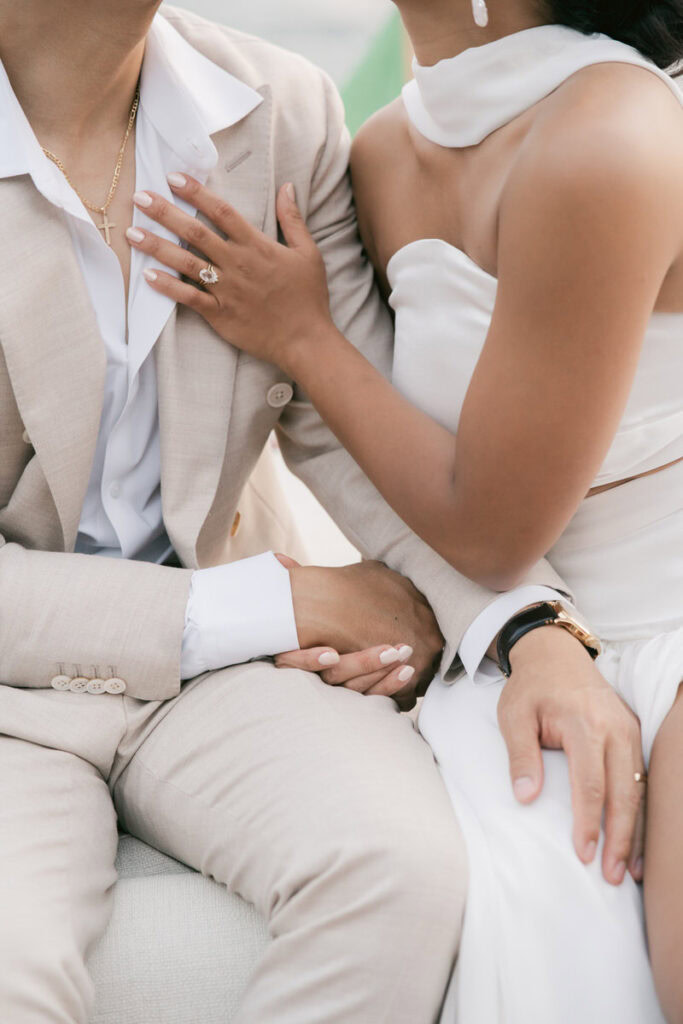 up close photo of bride touching groom's chest and showing off wedding ring
