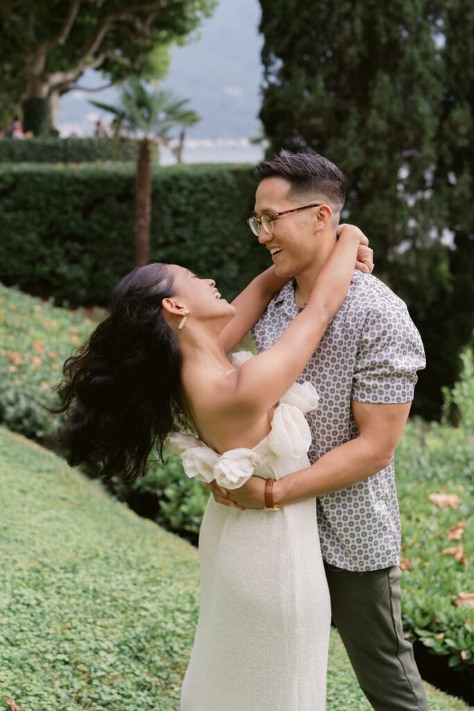 girl throws arms around guys head and they laugh