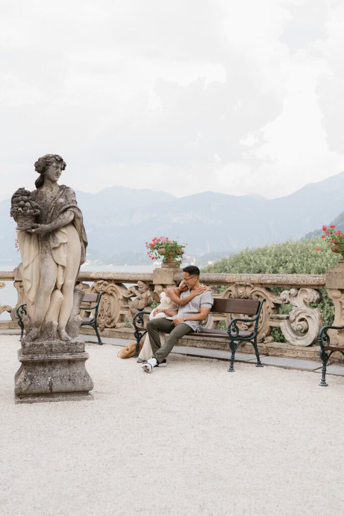 girl rests head on guys shoulder during engagement photos with lake como in the background